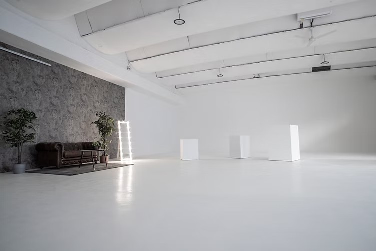 Bicocca studio: white cyclorama, white plinths and a lounge corner